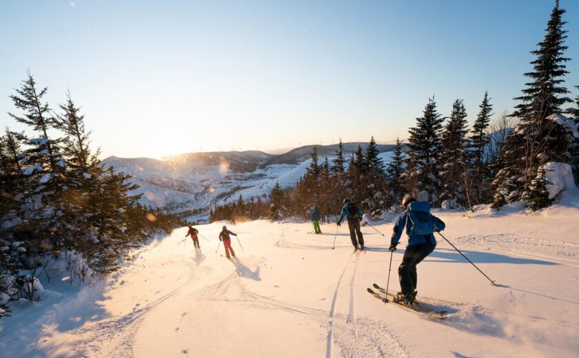 Skiers descending snowy mountain slope
