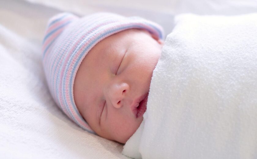 Sleeping newborn wrapped in blanket