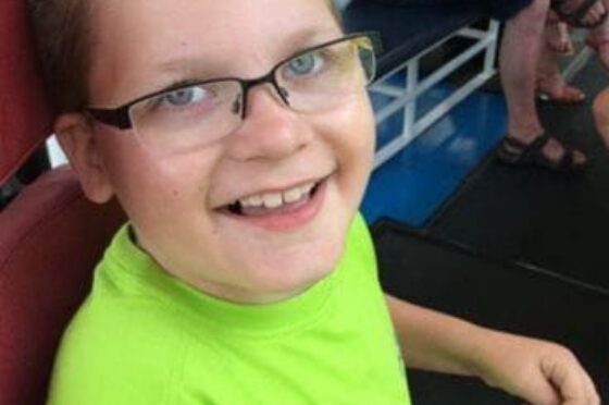 Smiling child with glasses seated indoors