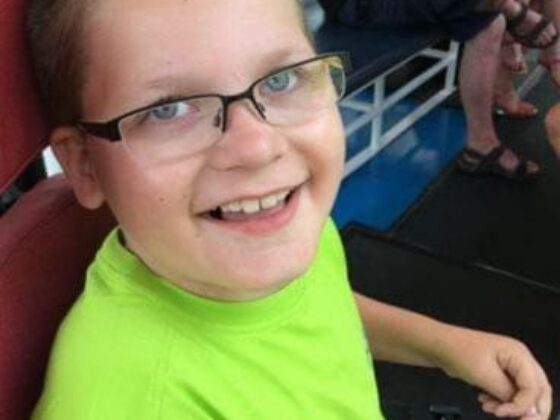 Smiling child with glasses seated indoors