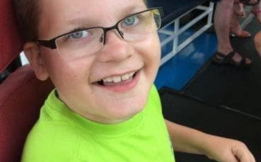 Smiling child with glasses seated indoors