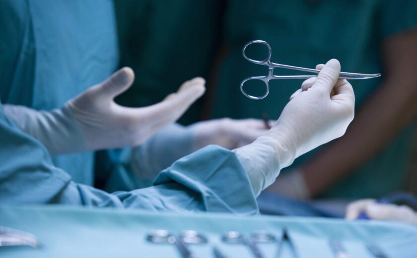 Surgeon holding forceps during operation