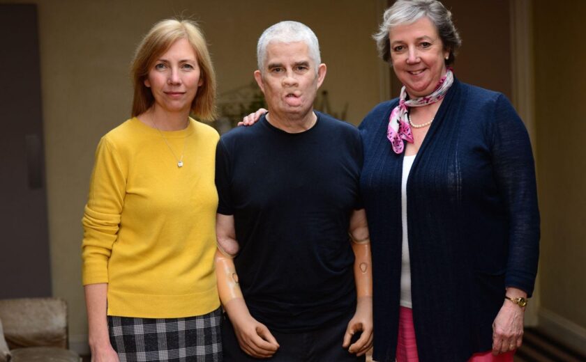 Three people standing together indoors