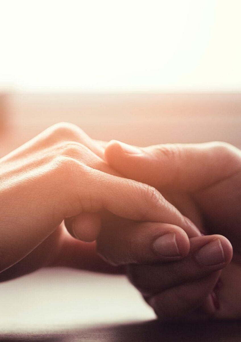 Two people holding hands in warm light