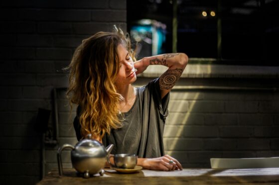 Woman clutching her back at kitchen table