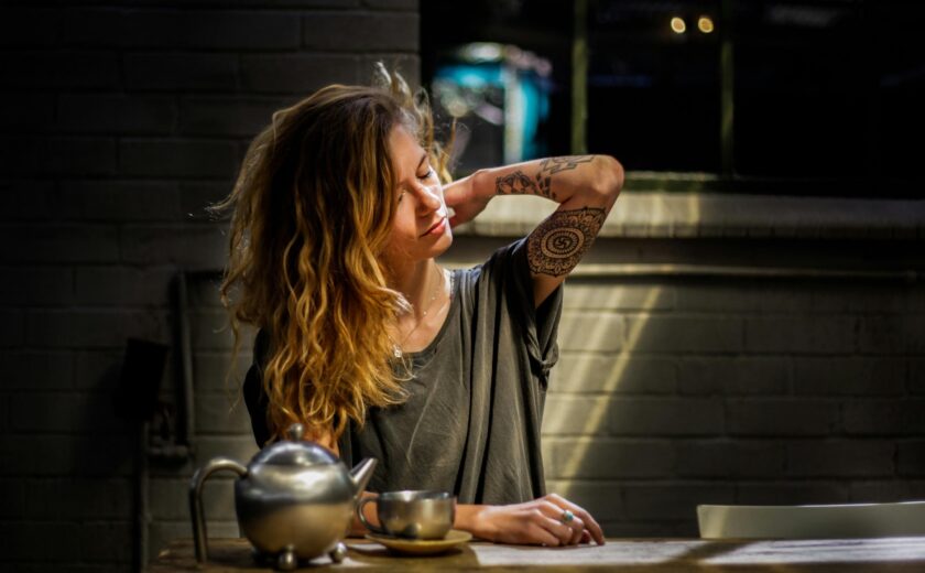 Woman clutching her back at kitchen table