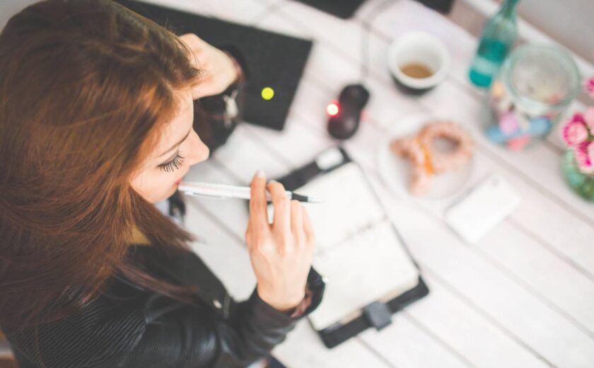 Woman working at desk with notebook