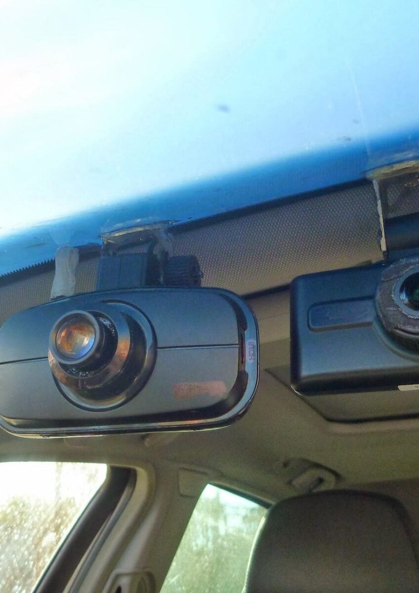 Two dash cameras mounted inside a vehicle on the front windshield