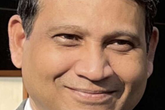 Man wearing suit and tie smiling at camera