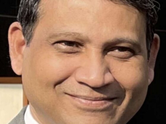 Man wearing suit and tie smiling at camera