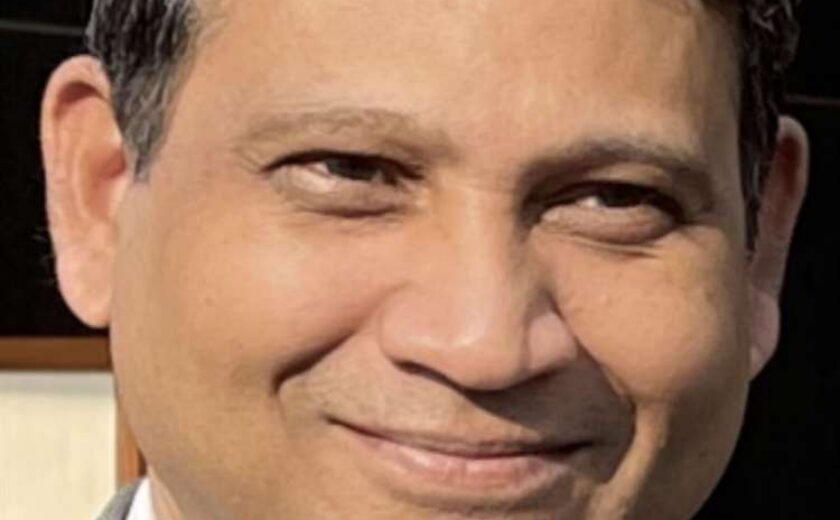 Man wearing suit and tie smiling at camera