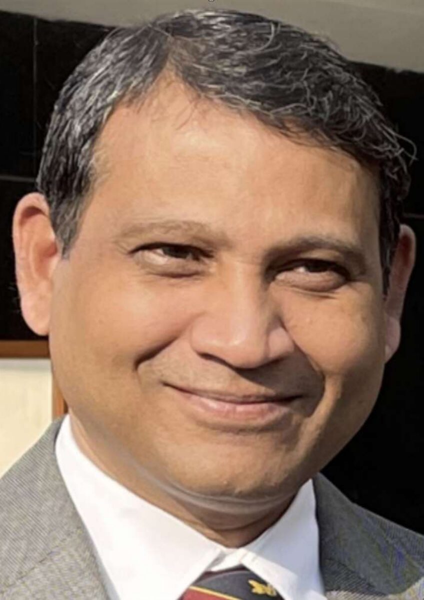 Man wearing suit and tie smiling at camera