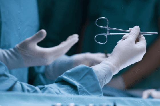 Hands of medical professional holding surgical instrument in operating room