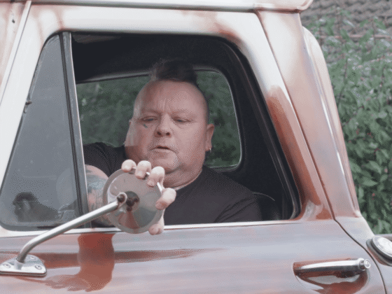 Robert driving a red car
