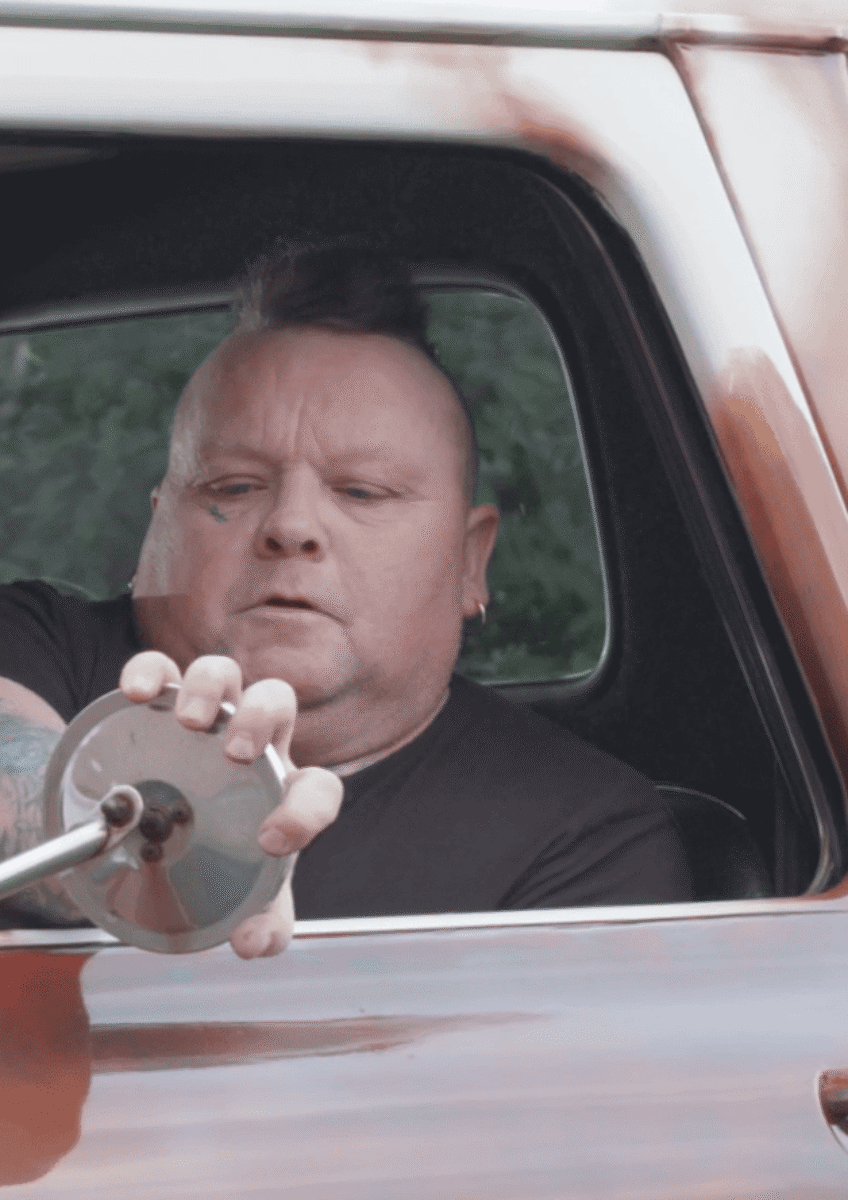 Robert driving a red car