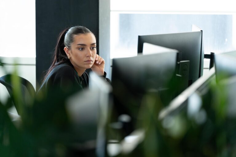 Female sat at desk looking at monitors