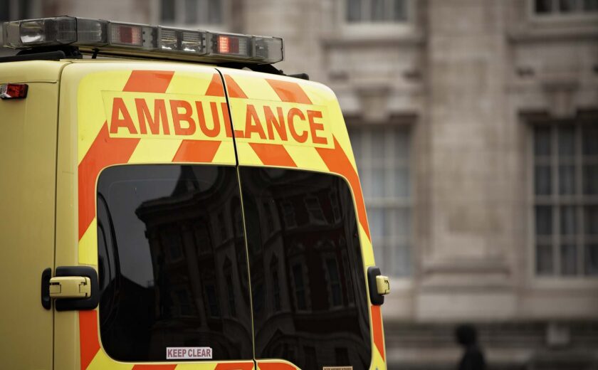 Rear of a yellow ambulance with orange chevrons and 'AMBULANCE' text
