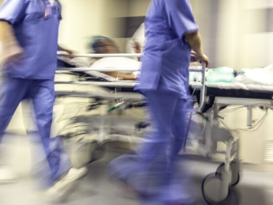 Blurred hospital corridor with medical staff pushing patient on trolley