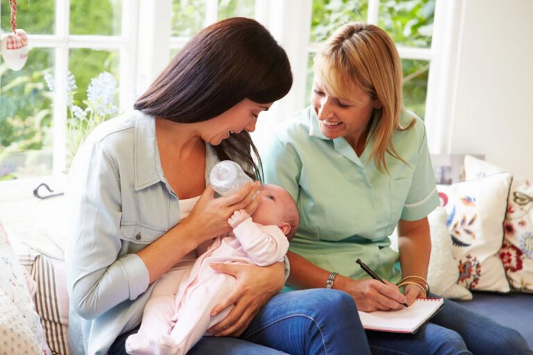 Mother feeding baby with-midwife