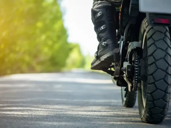 Motorcyclist's boot on footpeg of motorcycle on rural road