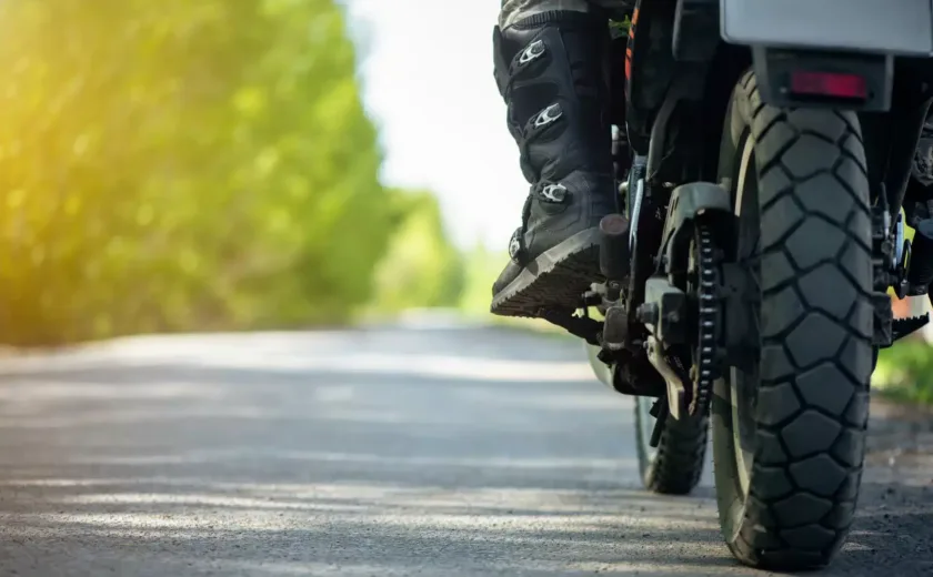 Motorcyclist's boot on footpeg of motorcycle on rural road