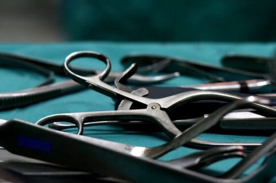 Close-up of surgical instruments laid out on sterile green drape