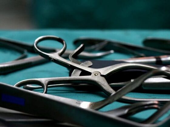 Close-up of surgical instruments laid out on sterile green drape
