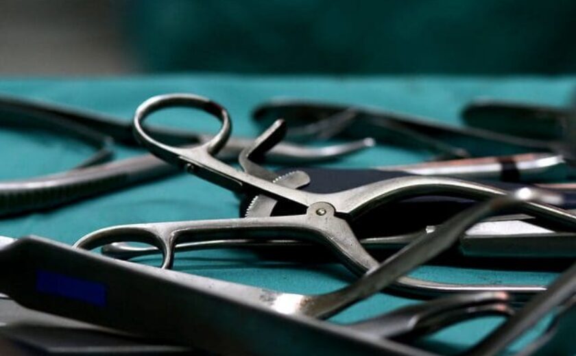 Close-up of surgical instruments laid out on sterile green drape