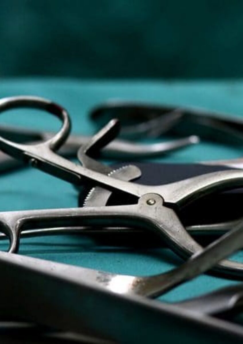 Close-up of surgical instruments laid out on sterile green drape