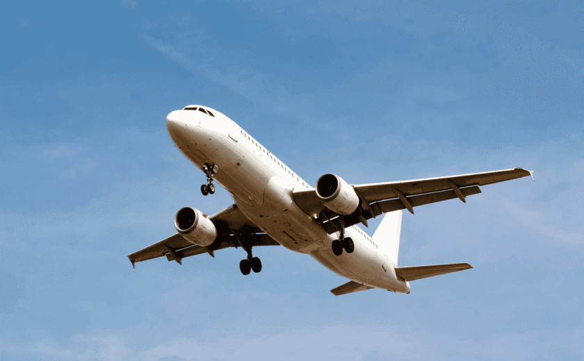 White passenger airplane flying against clear blue sky