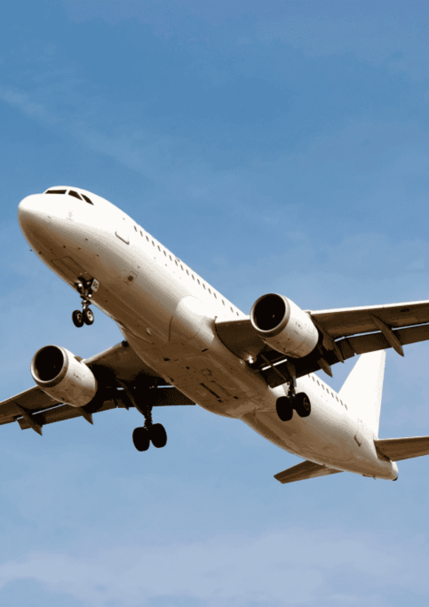 White passenger airplane landing with landing gear down in blue sky