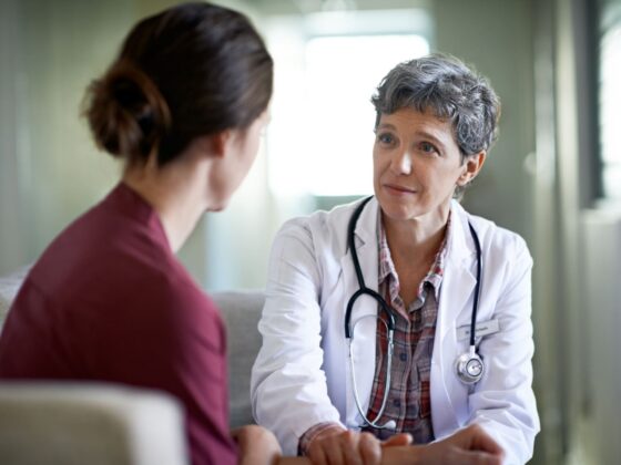 Female doctor listening attentively to a female patient in a consultation room